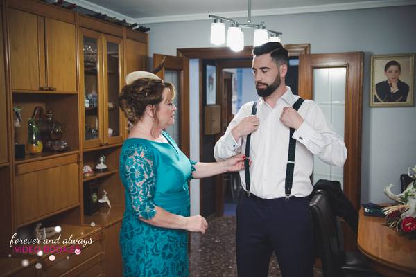 La madre del novio de la boda ayudando a bestirse